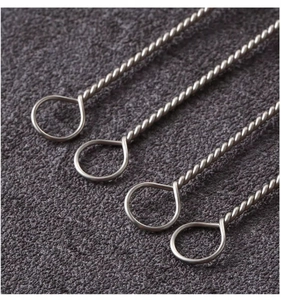 Detail view of 4-piece twisted stainless steel handles with ring ends on grey felt