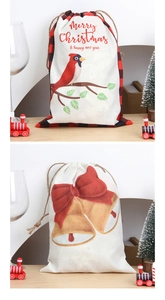 Detail of linen Christmas drawstring bags with festive bird and bell prints on wood