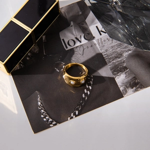 Golden wide pearl ring displayed on a fashion magazine with elegant vintage aesthetics
