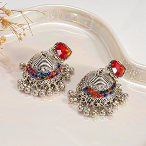 Detailed view of silver Jhumka earrings with multicolor rhinestones on iridescent tray