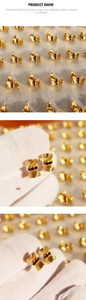 Detail of gold bow earrings with vertical stripes and black zircon center stone inlay