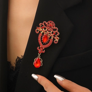 Baroque crystal brooch with red rhinestones pinned on a black suit lapel detail
