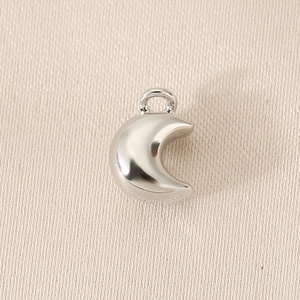Macro shot of silver metal moon-shaped pendant with a glossy finish for DIY jewelry
