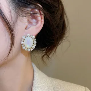 Elegant vintage oval earring with pearls and sparkling diamonds worn on a model