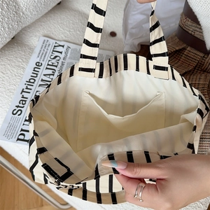 Detail of internal storage pocket and canvas texture inside the striped tote bag