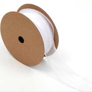 Detail of white semi-transparent organza ribbon roll with wavy edges for gift wrapping