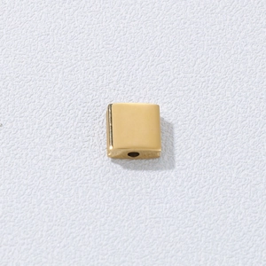 Macro shot of gold-plated square geometric spacer bead with center hole for DIY jewelry