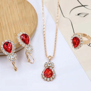 Detail view of red teardrop gemstone necklace, earrings and ring jewelry set for brides