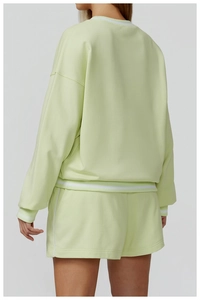 Close-up of mint green sweatshirt back showing ribbed cuffs and premium fabric texture