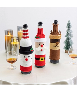 Dettaglio dei copribottiglie di vino natalizi lavorati a maglia con Babbo Natale e renna