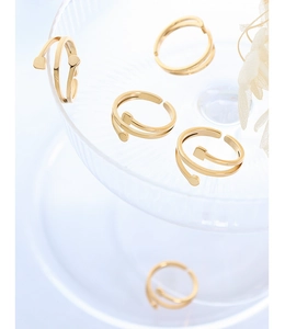Macro detail of 18K gold plated titanium steel spiral rings on a ribbed glass tray