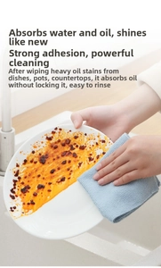 Microfiber blue waffle weave cloth removing heavy oil stains from a white ceramic plate