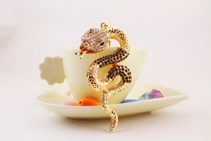 Detail of creative gold-tone snake keychain with sparkling rhinestones and scale texture