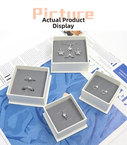 Flat lay of multiple jewelry gift boxes featuring silver necklaces, rings and earrings