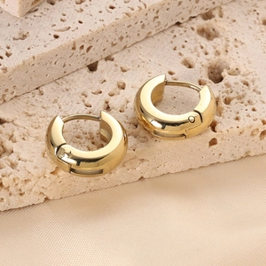 Polished 14K gold stainless steel chunky C-shaped hoop earrings on silk background