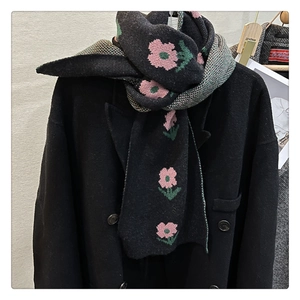 Detail of floral knit scarf showing black and pink flower patterns with houndstooth texture