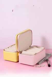 Travel jewelry storage cases in pastel pink and yellow PU leather with zipper closure