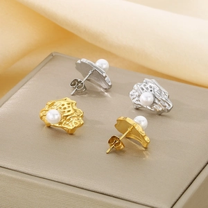 Detailed view of irregular textured gold and silver earrings with centered pearls