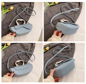 Détail du sac selle bleu clair avec poignée en métal argenté et texture cuir mat