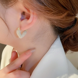 Elegant gold V-shaped heart stud earrings with small white pearls for a French chic style