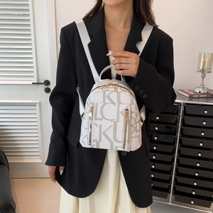 Chic white monogram backpack with gold zippers shown on a model for a stylish casual look