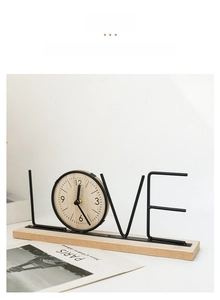 Detail of creative LOVE shaped silent desk clock with wooden dial and metal frame