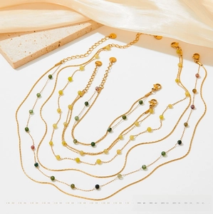 Detail view of gold stainless steel jewelry set with colorful natural stone beads