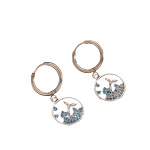 Silver hollow dolphin tail necklace set with blue gemstones on white background