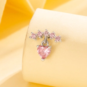 Pink heart pendant earring with silver metal and small pink gemstones on paper background