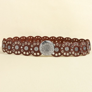 Detail of vintage brown leather belt with silver floral rivets and engraved sunburst buckle