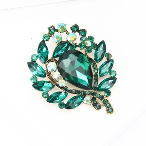 Elegant gold leaf brooch with green teardrop crystal and sparkling rhinestones