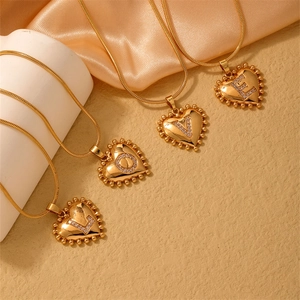 Detail of four-piece gold heart LOVE necklaces with rhinestones on snake chains