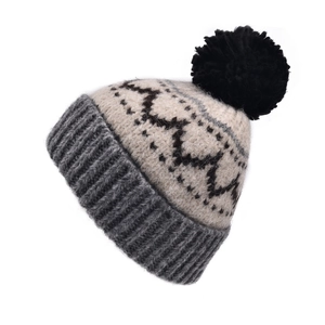 Détail en gros plan d'un bonnet en maille jacquard vintage avec pompon noir duveteux