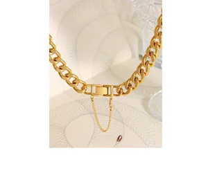 Macro view of gold plated chunky cuban chain necklace with safety buckle and clasp detail