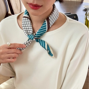 Detail of a 70cm geometric silk-like scarf with black white checks and teal stripes