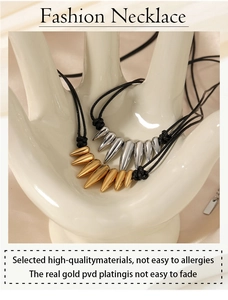 Detailed shot of gold and silver spiked necklaces on a ceramic hand display stand