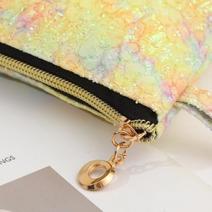 Macro shot of rainbow lace makeup bag with gold zipper and sparkly glitter texture