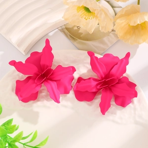 Detail view of large hot pink metallic flower earrings on a white textured tray