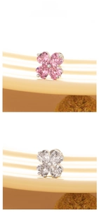 Macro shot of clover earrings with pink heart-shaped stones and silver steel base