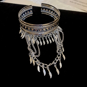 Vue détaillée du bracelet à plumes argenté avec pompons de chaînes sur velours noir