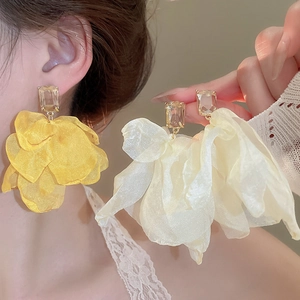 Detail of oversized fabric flower earrings with mesh petals and clear crystal base