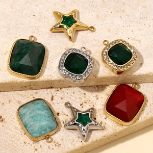 Star and square titanium steel pendants with colorful natural stones on beige rock