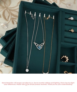 Macro shot of silver necklaces and rings on premium dark green velvet jewelry display trays