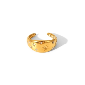 Detailed view of gold plated wide band ring with engraved stars and micro-set cubic zirconia