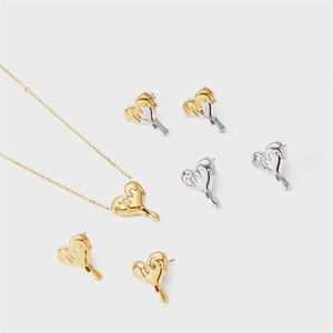 Detail view of heart-shaped fluid metal studs and necklace in gold and silver finish