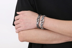 Detailed view of vintage punk style thick titanium steel chains worn on a male wrist