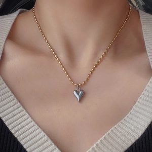 Collier avec pendentif cœur bicolore, chaîne à billes dorée et cœur 3D en argent poli