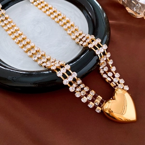 Detailed macro view of triple-row rhinestone waist chain with gold heart pendant