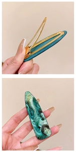 Macro view showing marble texture and golden metal base of the French vintage hair clip