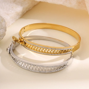 Detailed view of silver and gold zipper-style bangles with inset sparkling crystals
